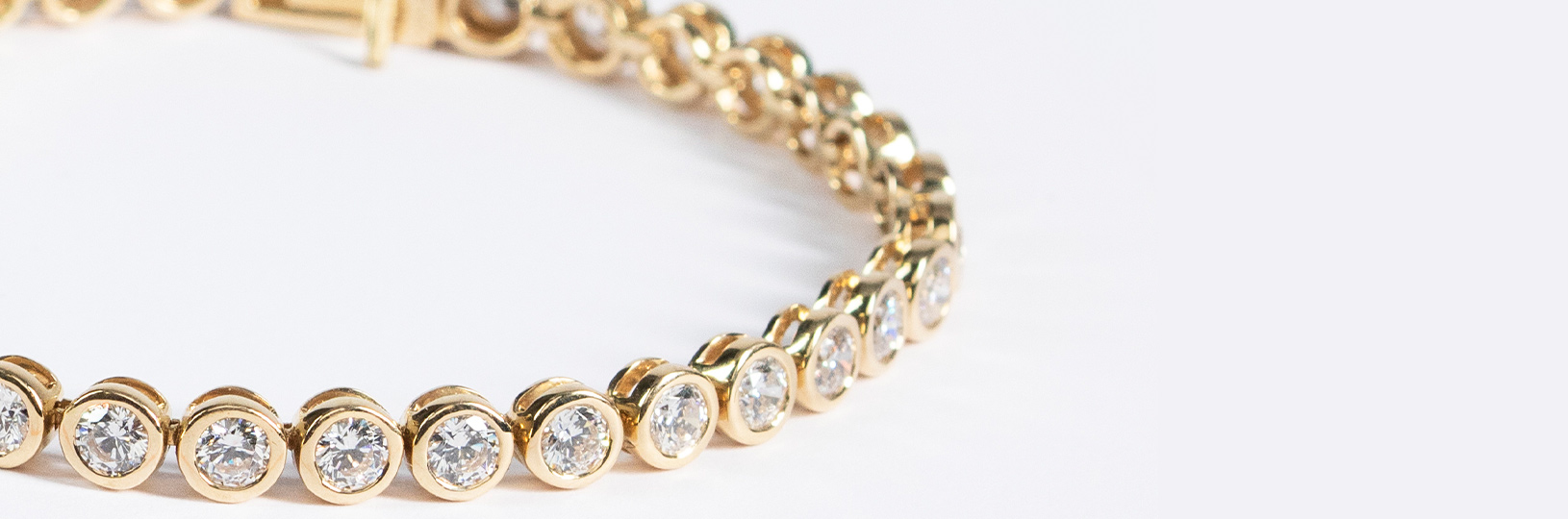A yellow gold bracelet featuring several round cut diamonds