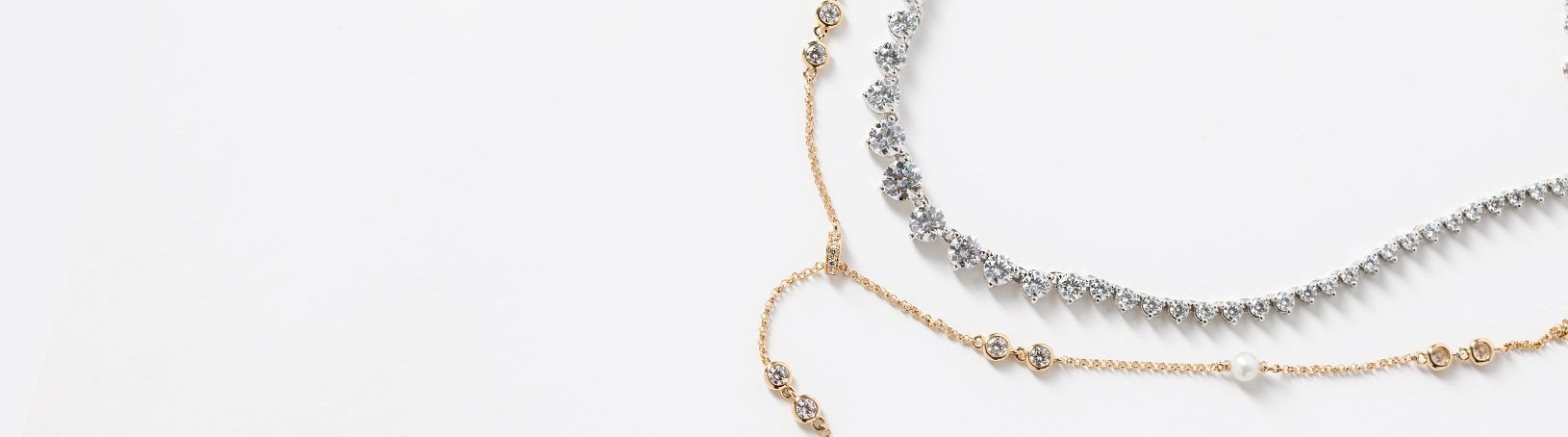 A yellow gold and a white gold necklace side by side