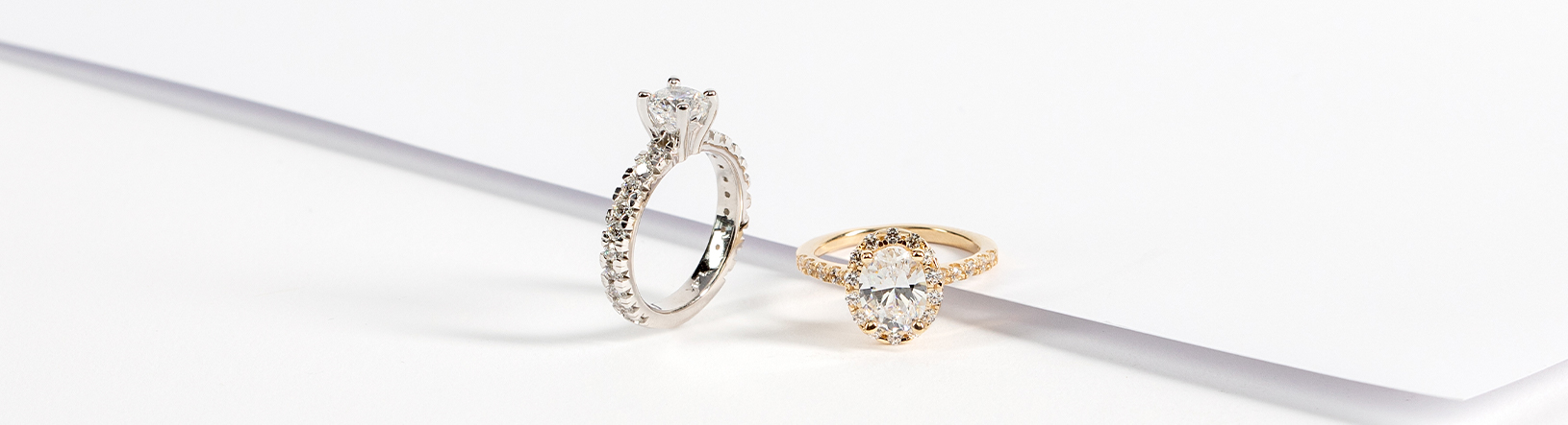 An oval engagement ring and a round engagement ring compared side by side